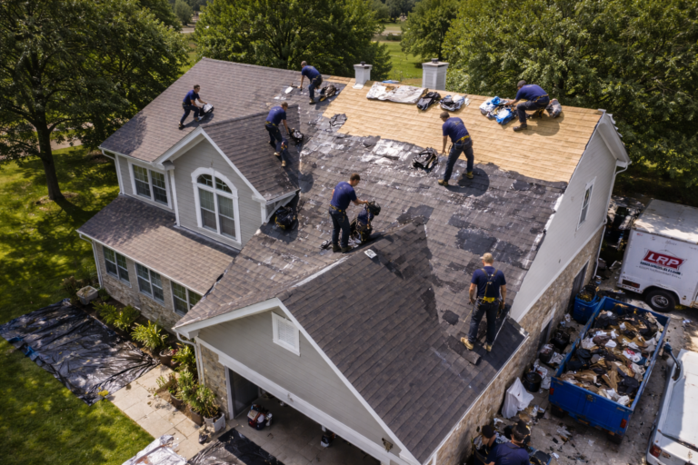 Aerial view of multiple roofers completing a full residential roof replacement on a Texas home