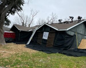 catch-all roofing system with protective netting installed around home during roof replacement