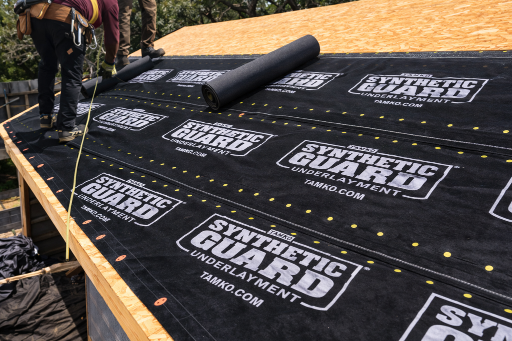 Roof underlayment installation using TAMKO synthetic guard underlayment on residential roof decking during replacement