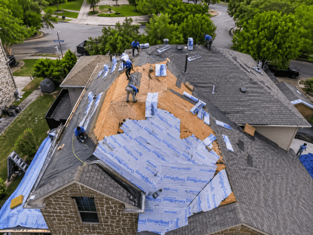 aerial view of roof repair in Round Rock TX with workers replacing shingles on residential home