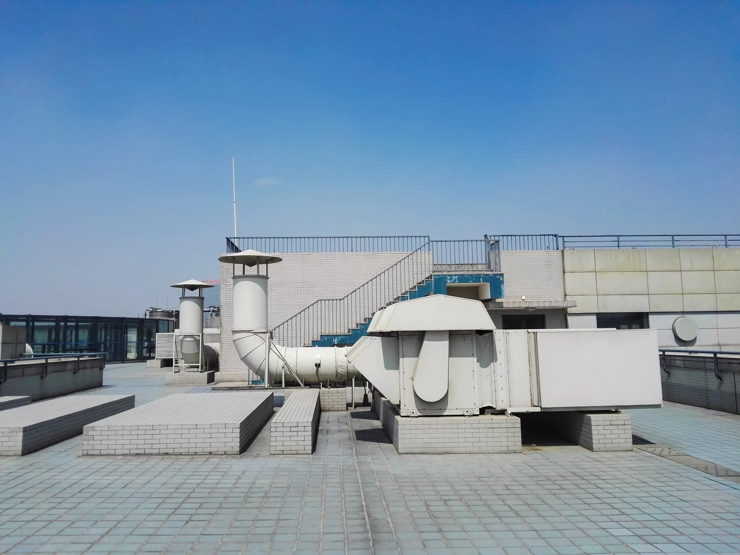 A commercial flat roof is shown with a variety of venting and HVAC system sections on the roof