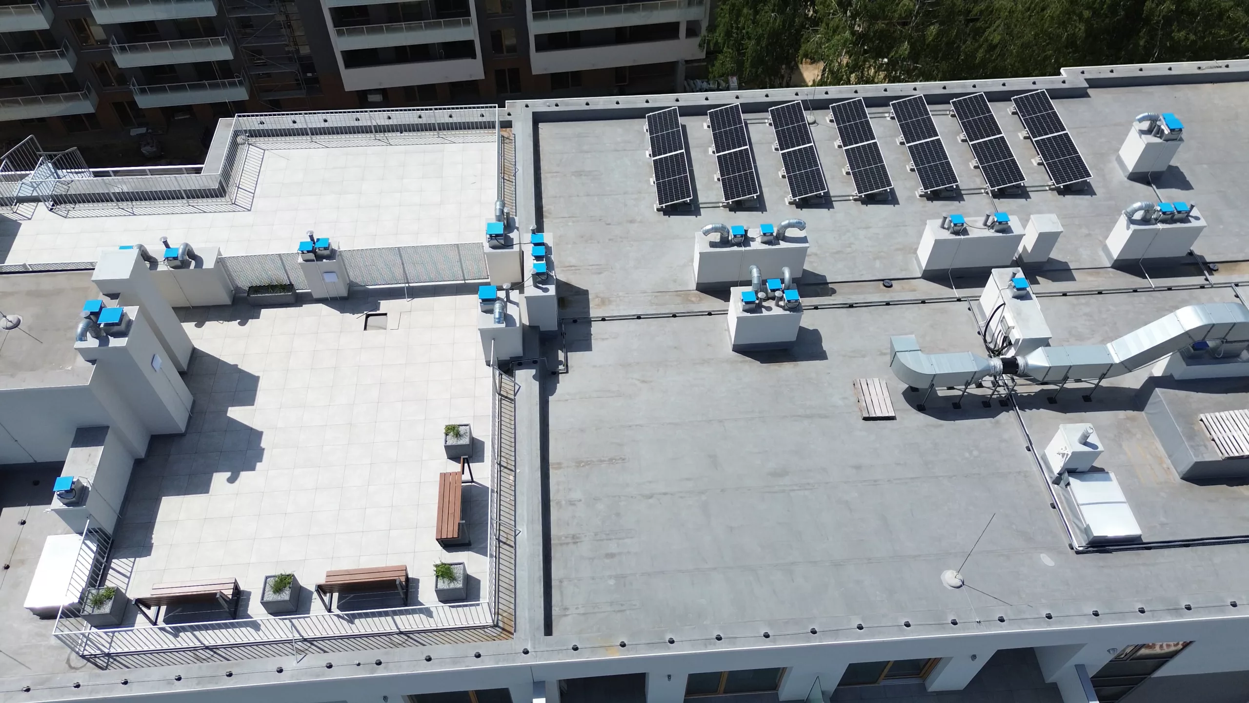 The image features a large commercial flat roof with a proper venting system and some mechanical structures