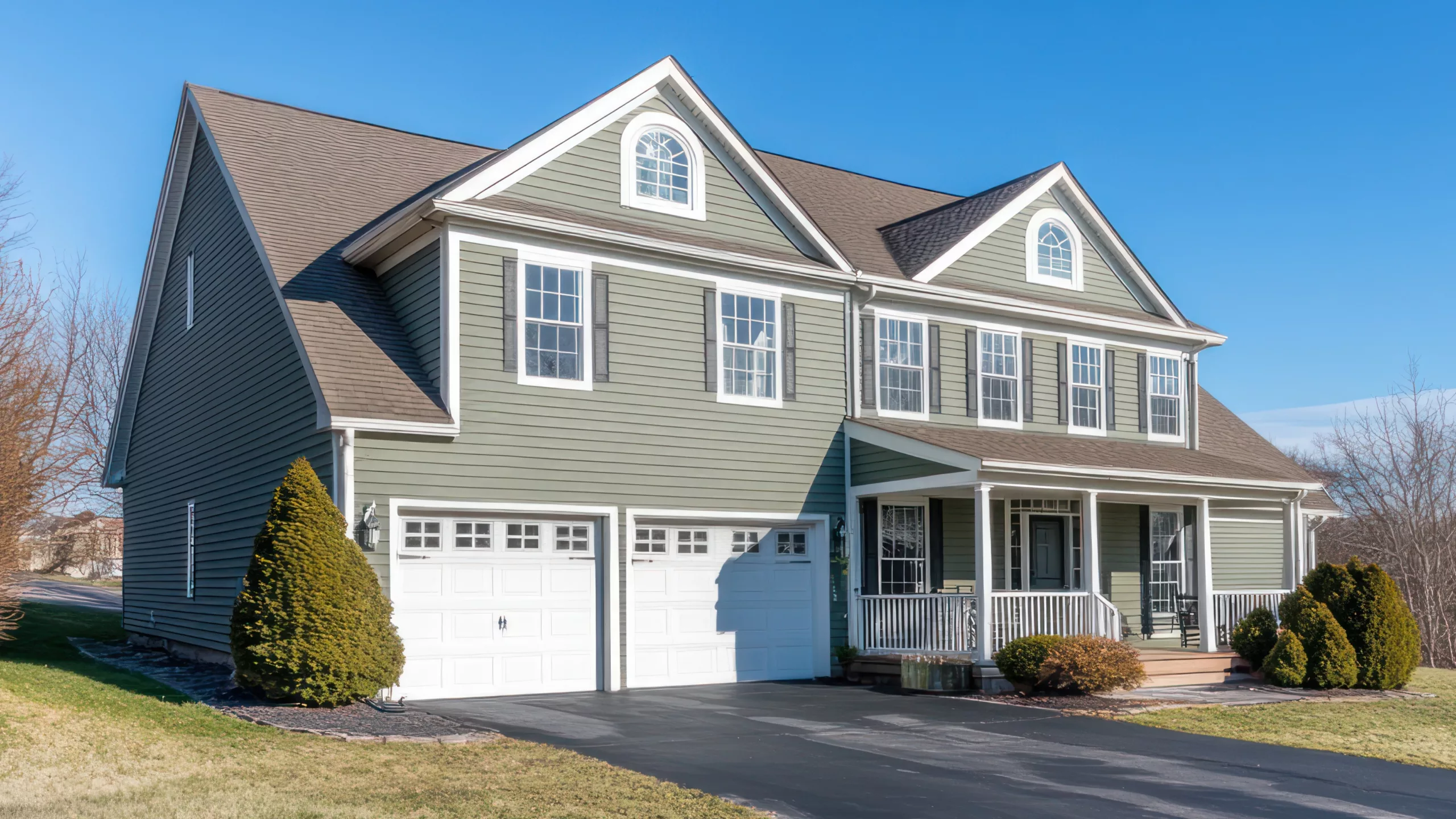 Wide home with cream-colored siding and asphalt-shingled roofing