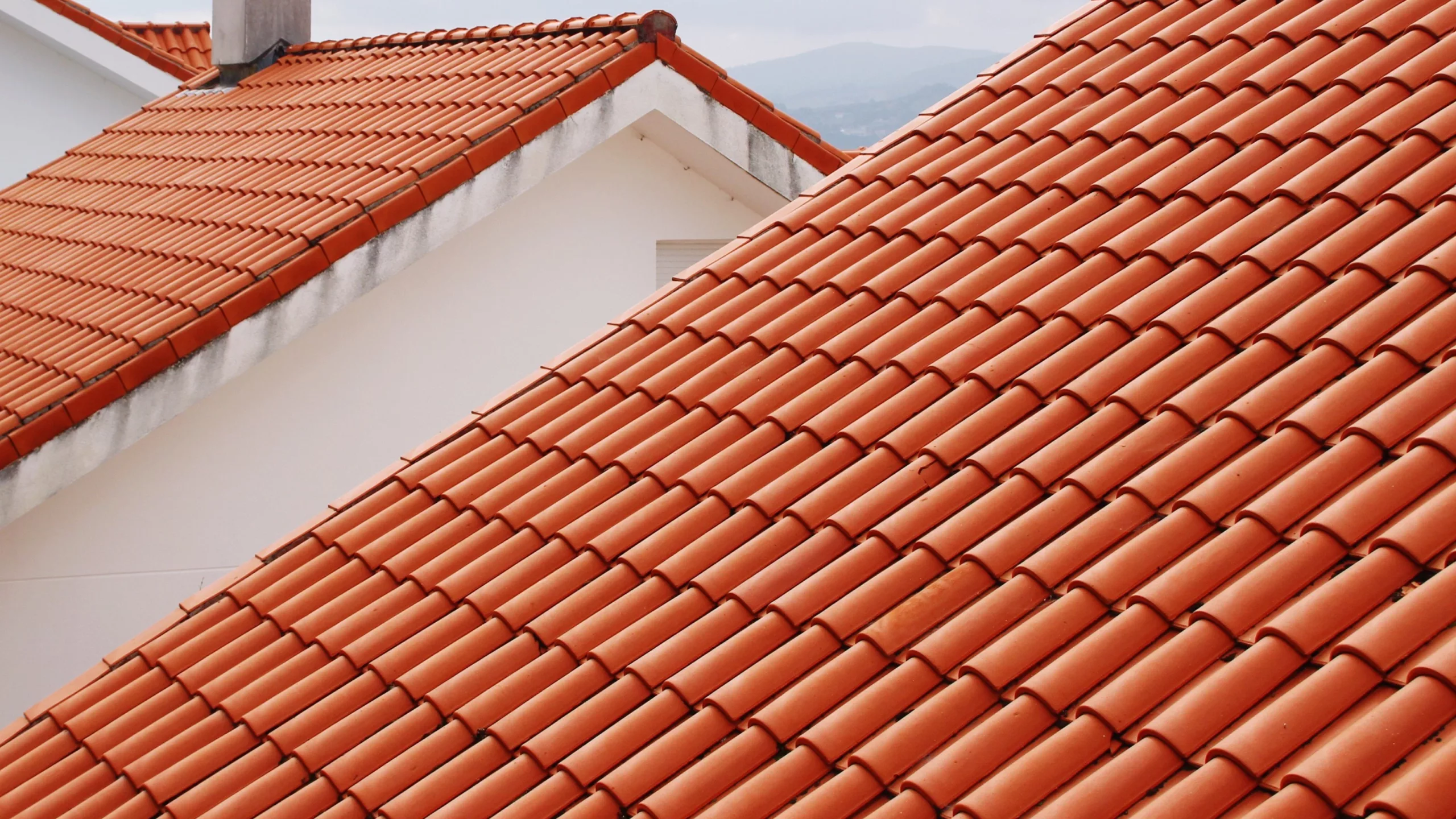 Two homes with bright orange tile roofs