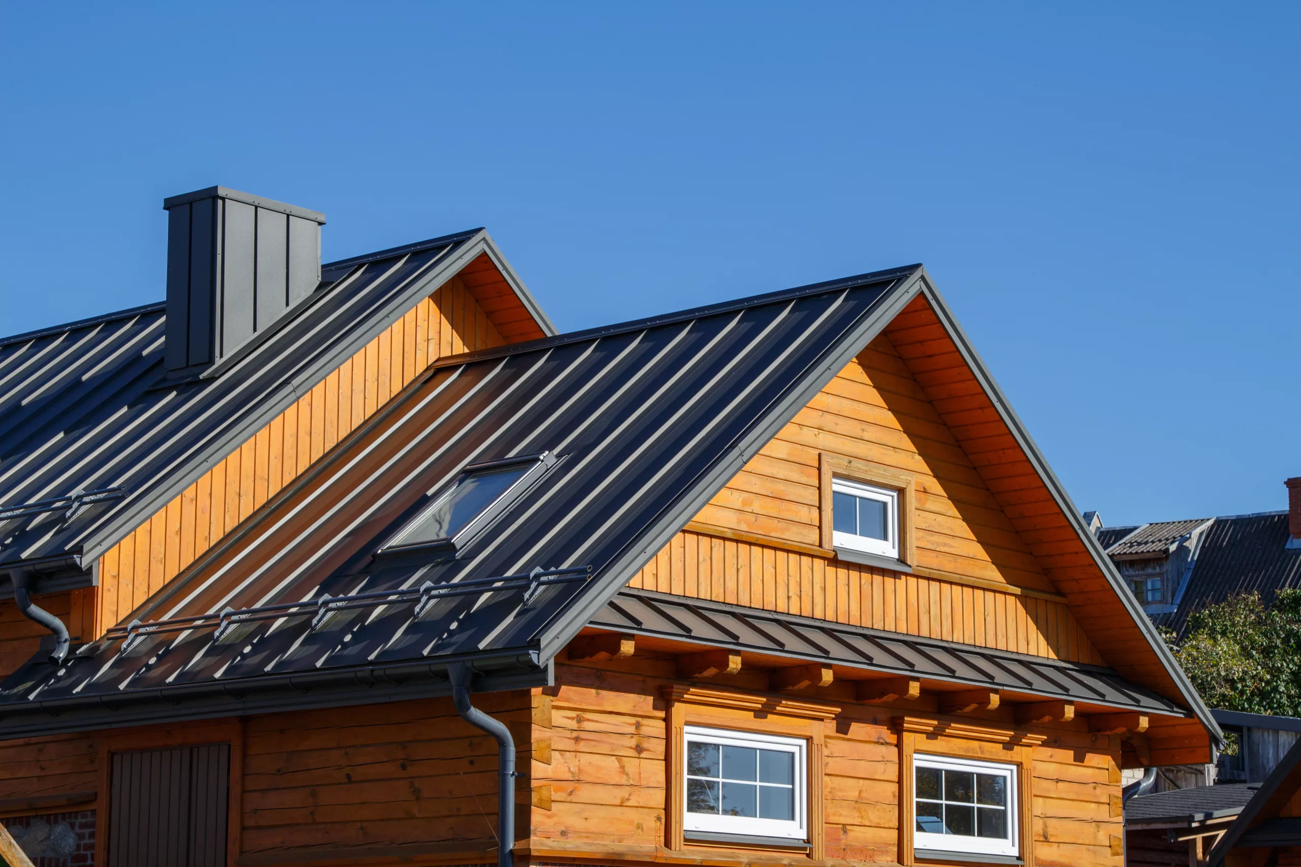 Black metal roof on a wood house