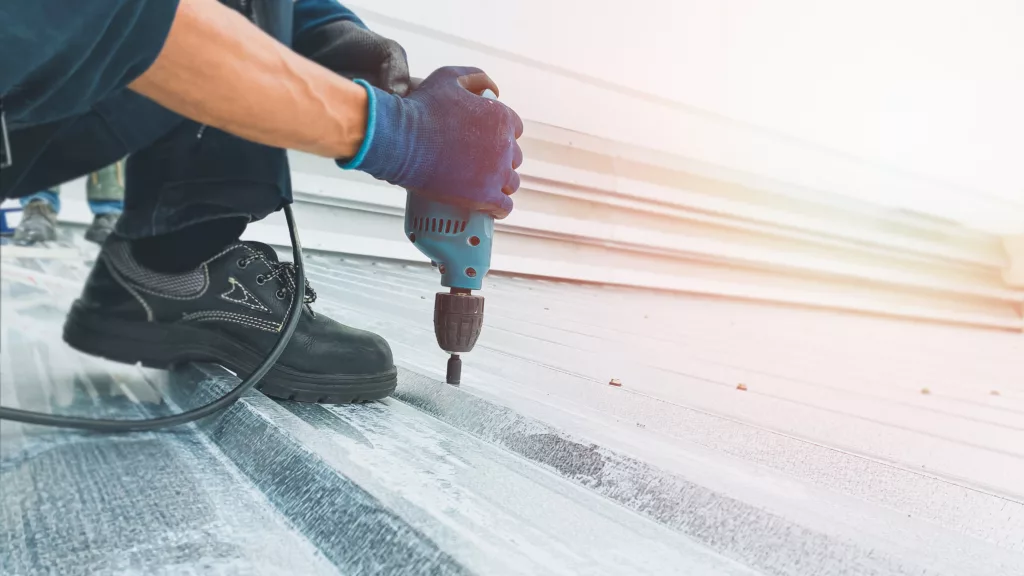 Roofer repairing metal commercial roof