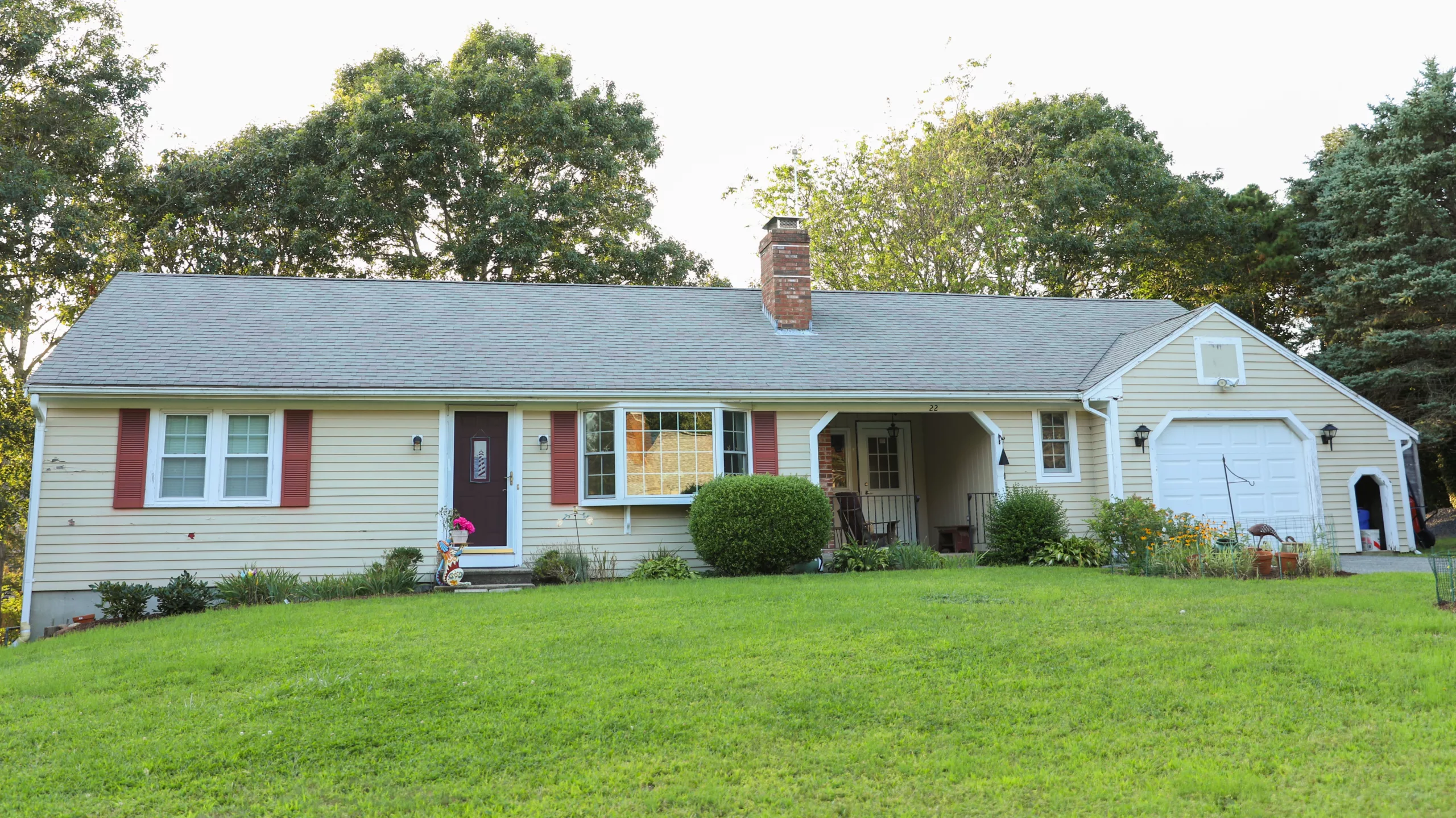Wide home with cream-colored siding and asphalt-shingled roofing
