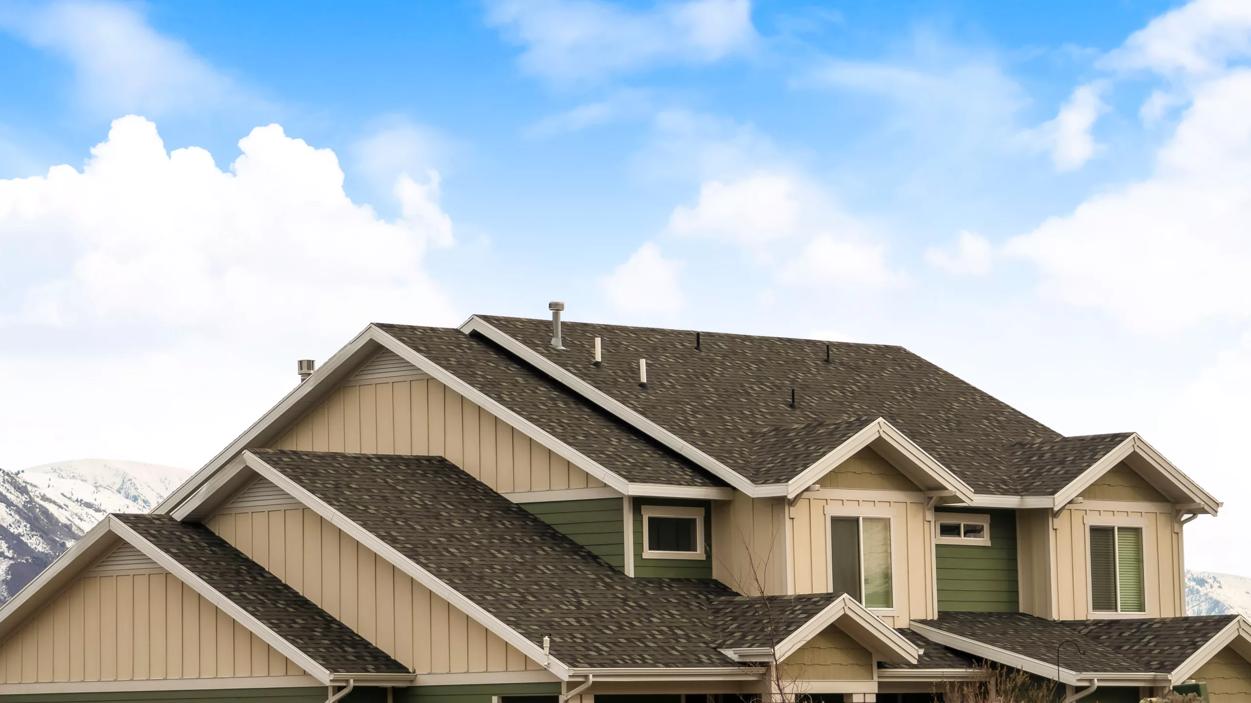 Asphalt shingle roof on a tan building