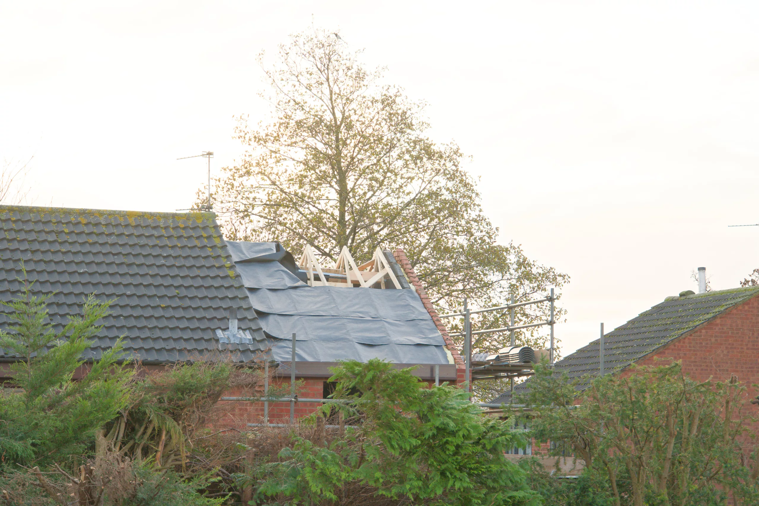 Red tile roof with part of it tarped from storm damage