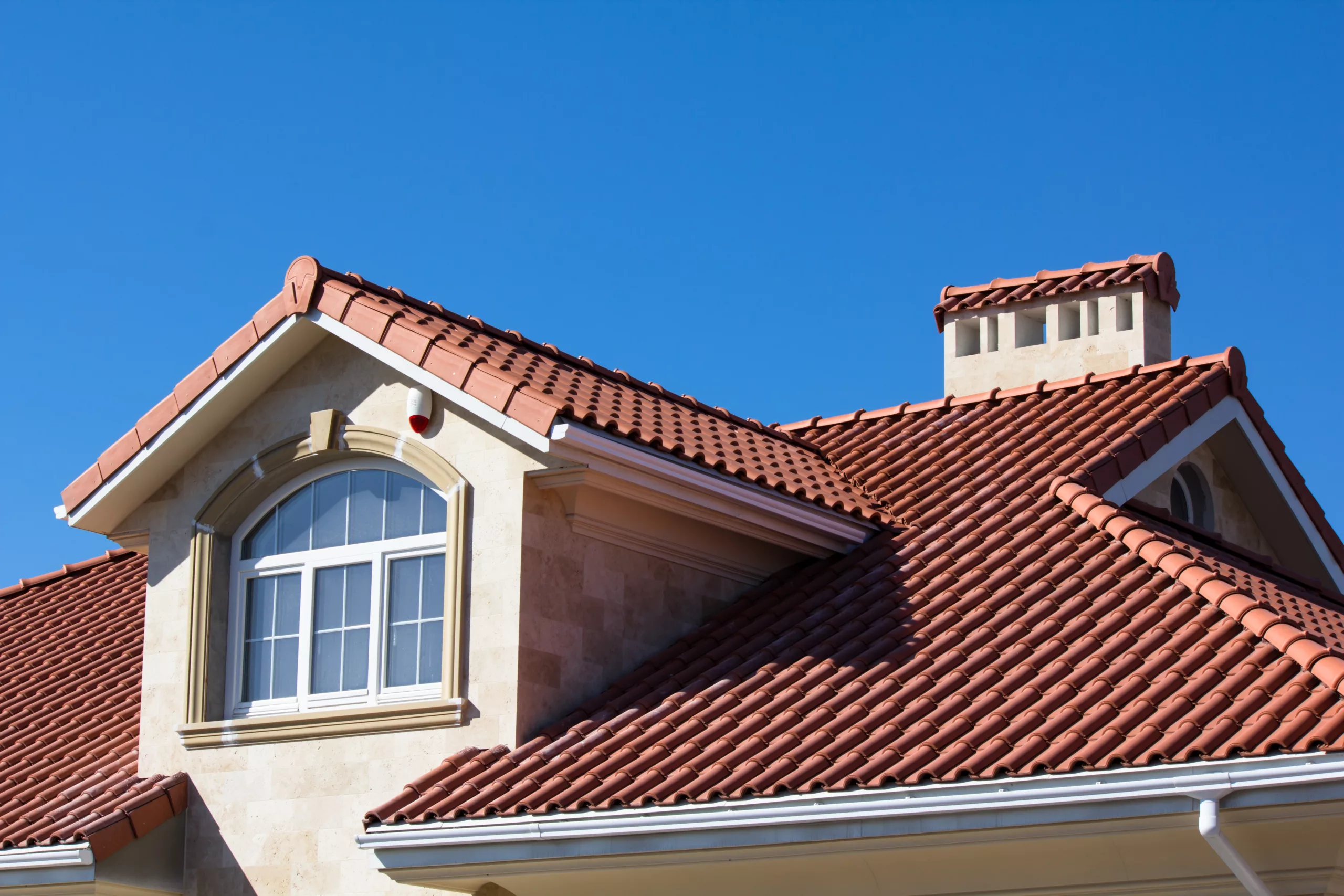 Tile roof on multi-story building with peak and windows