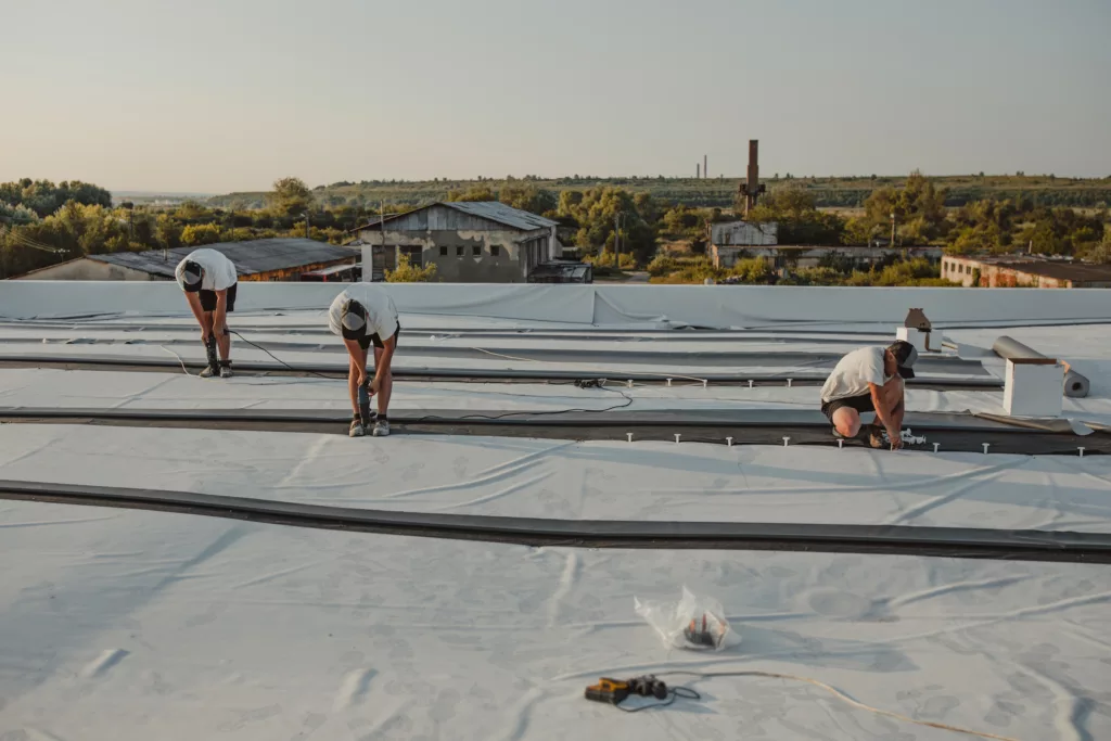 Workers repairing a flat roof on a commercial building