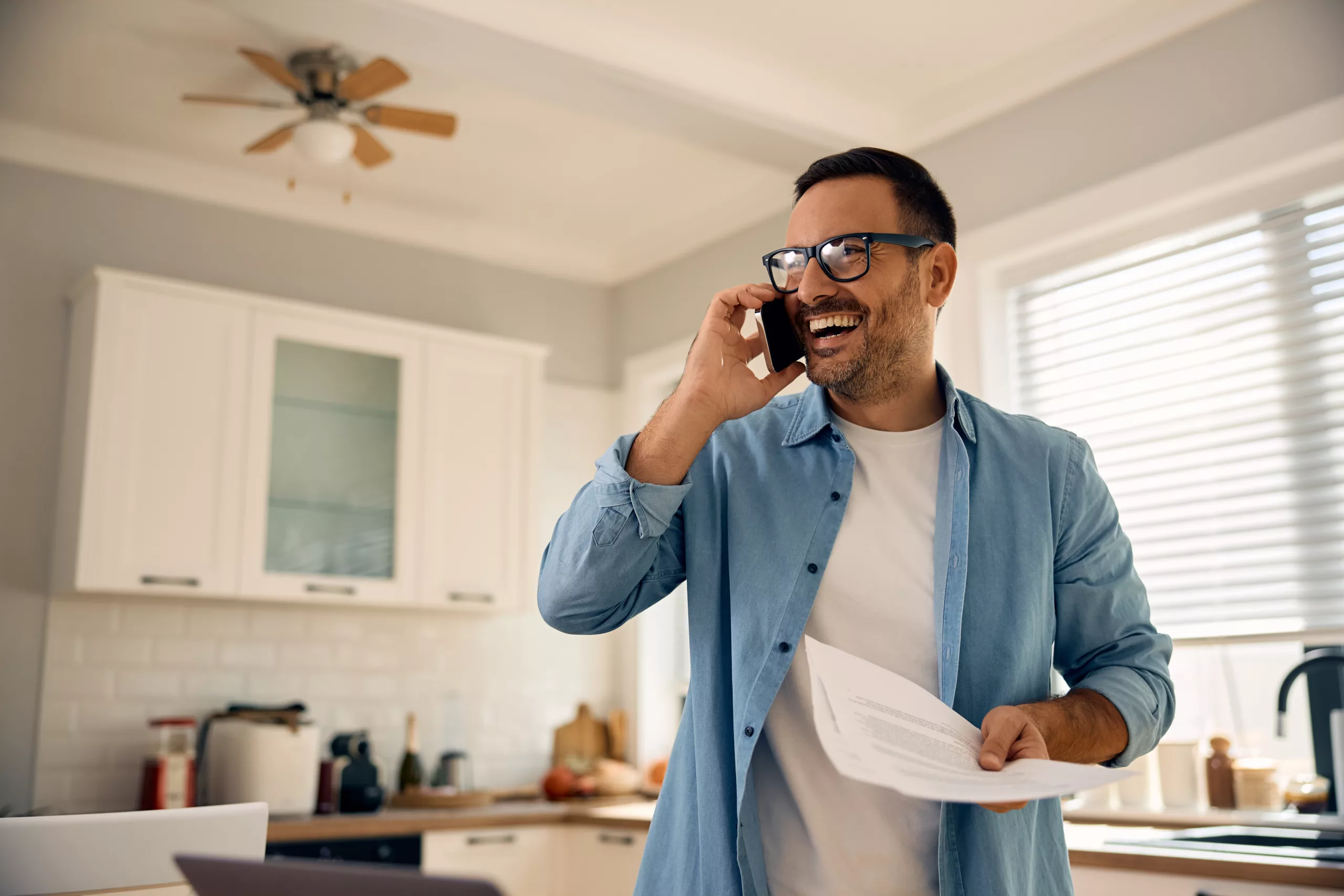 The image features a homeowner happy on the phone with the insurance company.