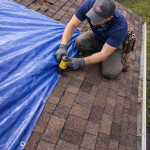Aerial view of emergency roof tarping on an asphalt shingle roof after storm damage in Texas