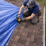 Aerial view of emergency roof tarping on an asphalt shingle roof after storm damage in Texas