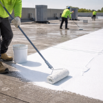 Technician applying roof coating repairs and reapplication on a commercial flat roof