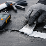 close-up of roofer repairing shingles on residential roof in Texas