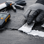 close-up of roofer repairing shingles on residential roof in Texas