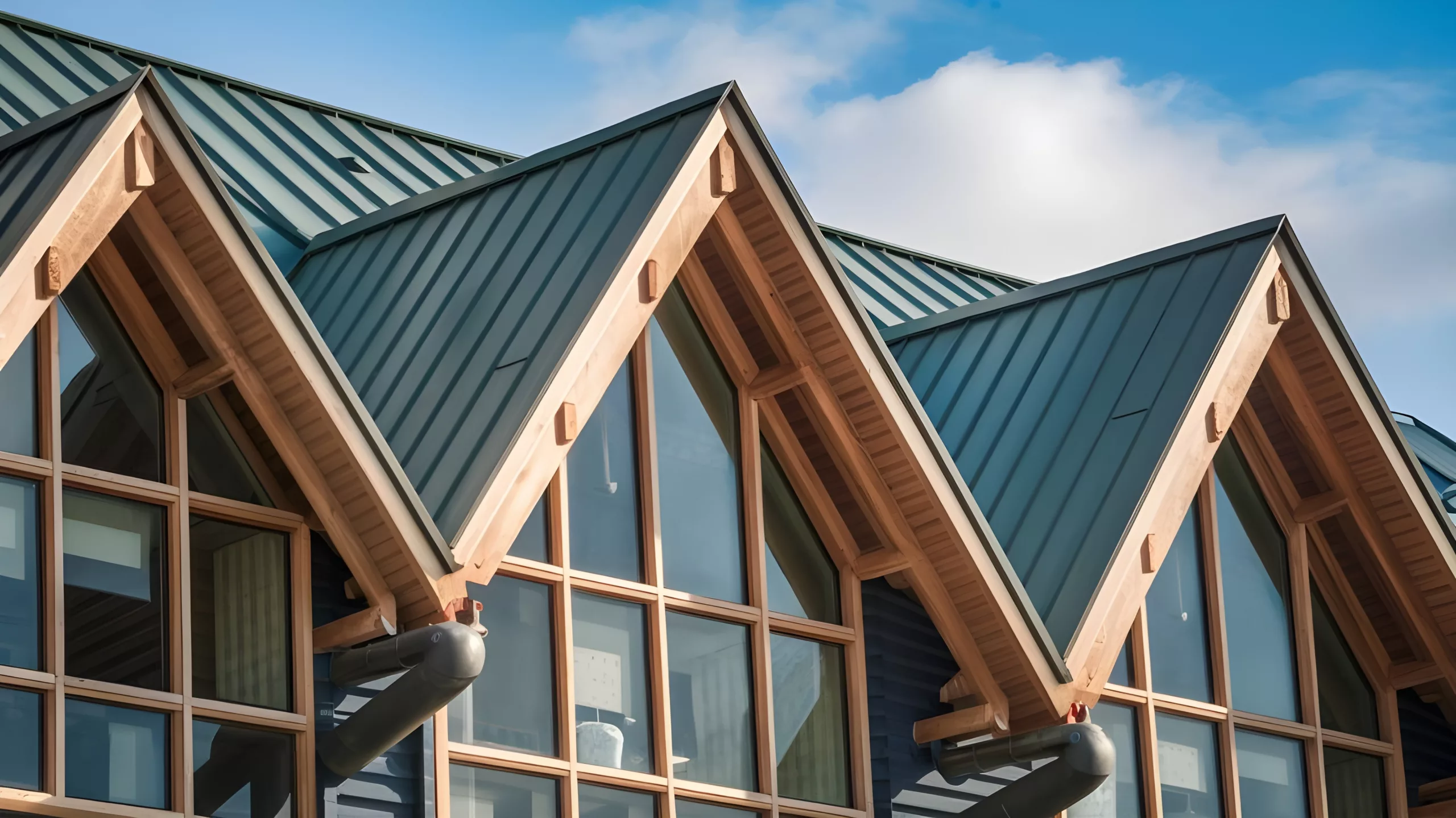 Green metal peaked commercial roof with big windows
