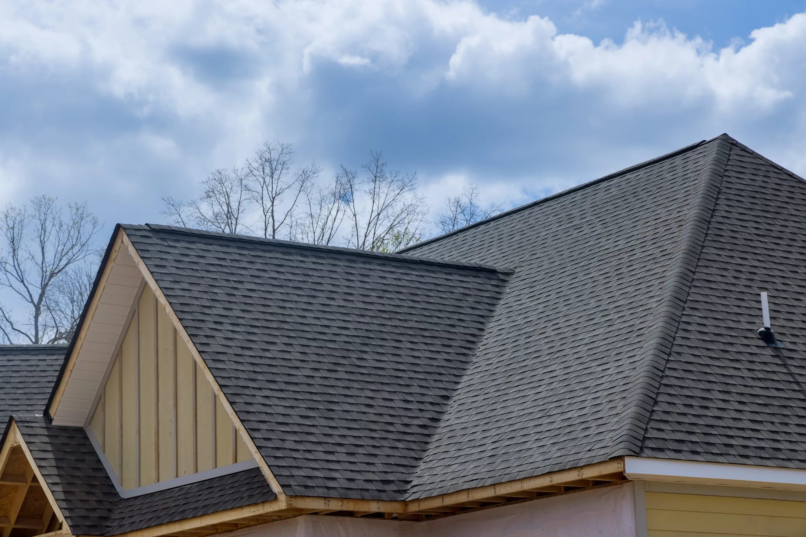 Asphalt shingle roof on a tan house