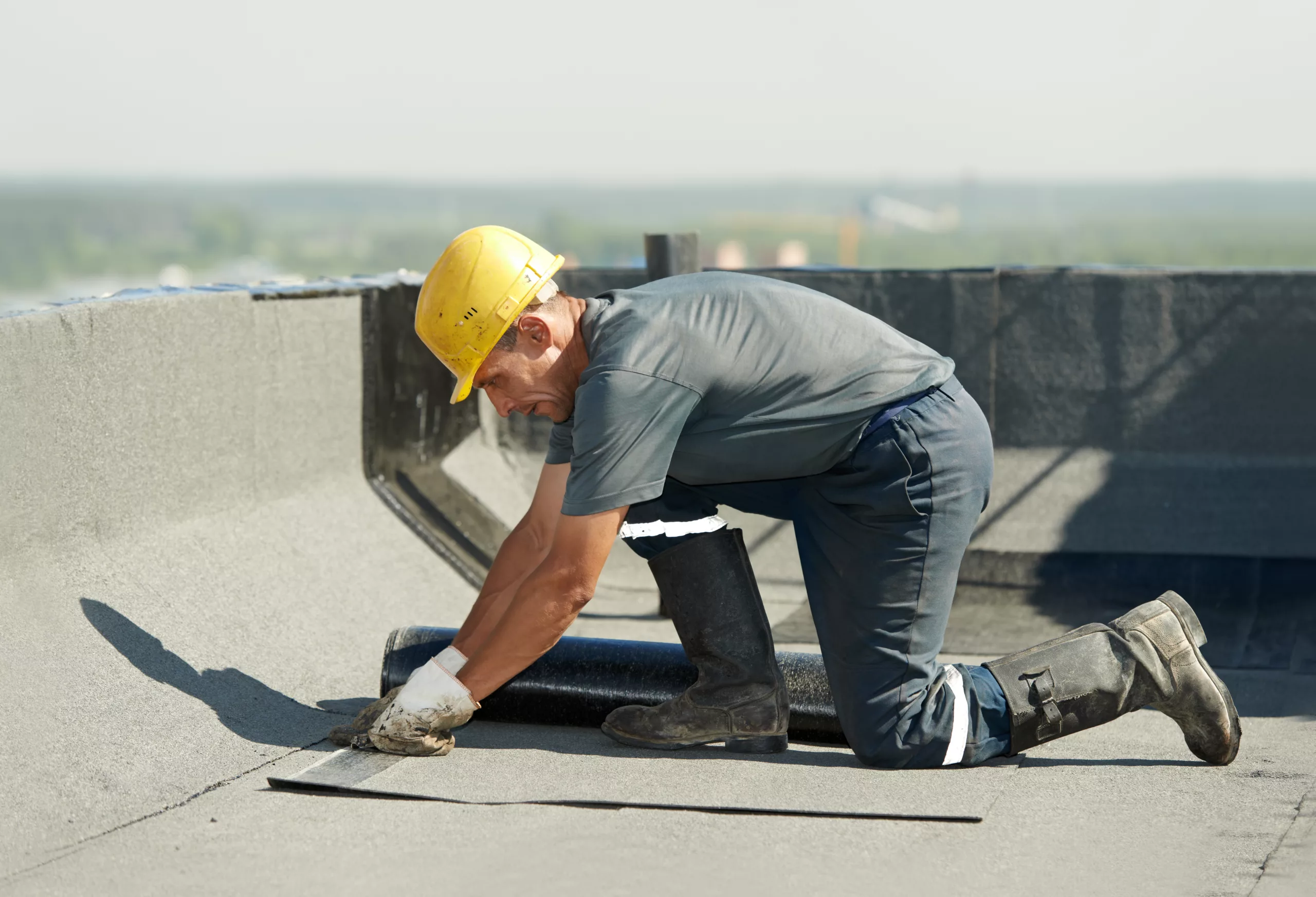 Worker repairing a flat commercial roof