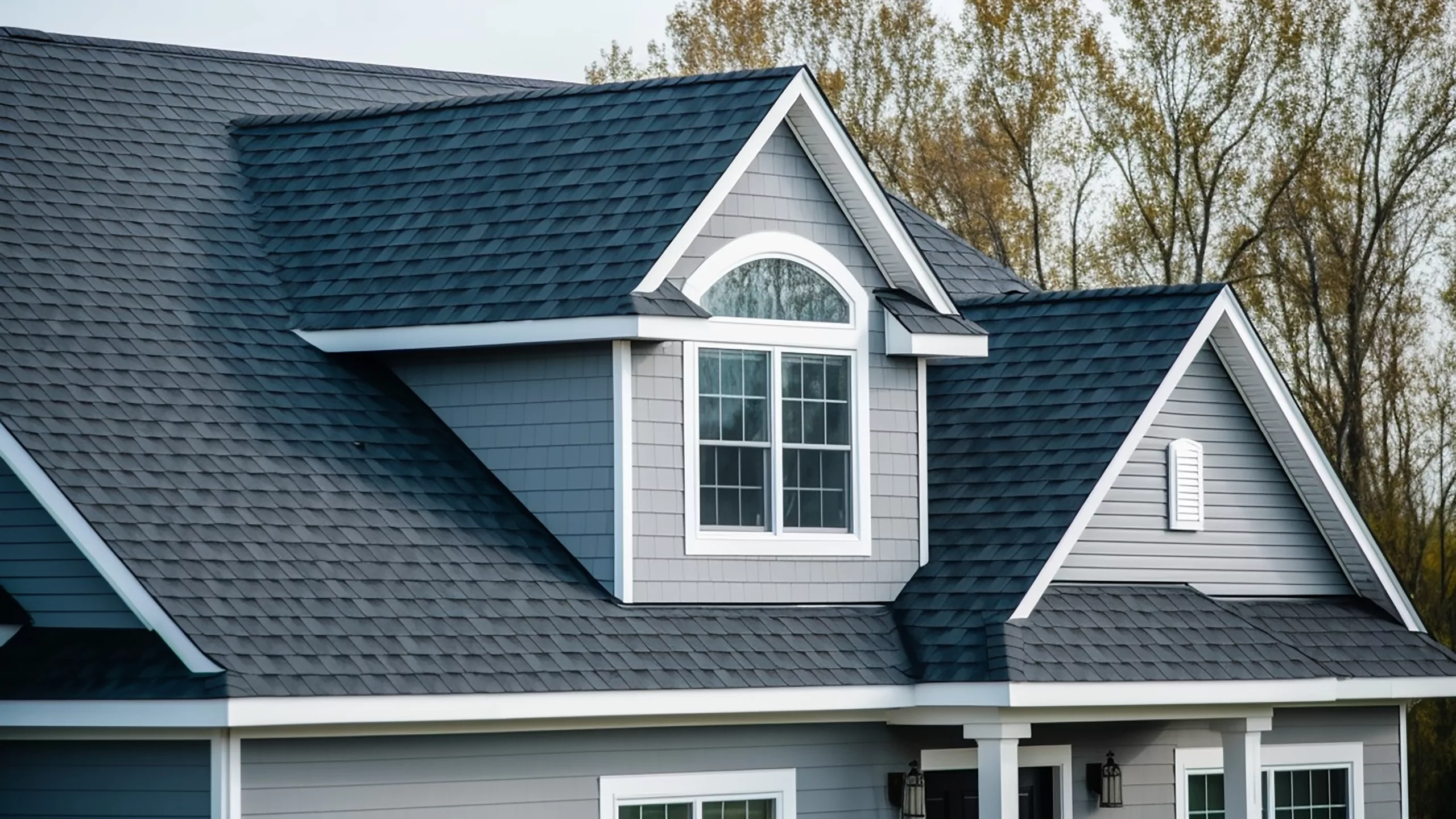 Beautifully kept dark asphalt shingle roof on a home with blue-gray siding