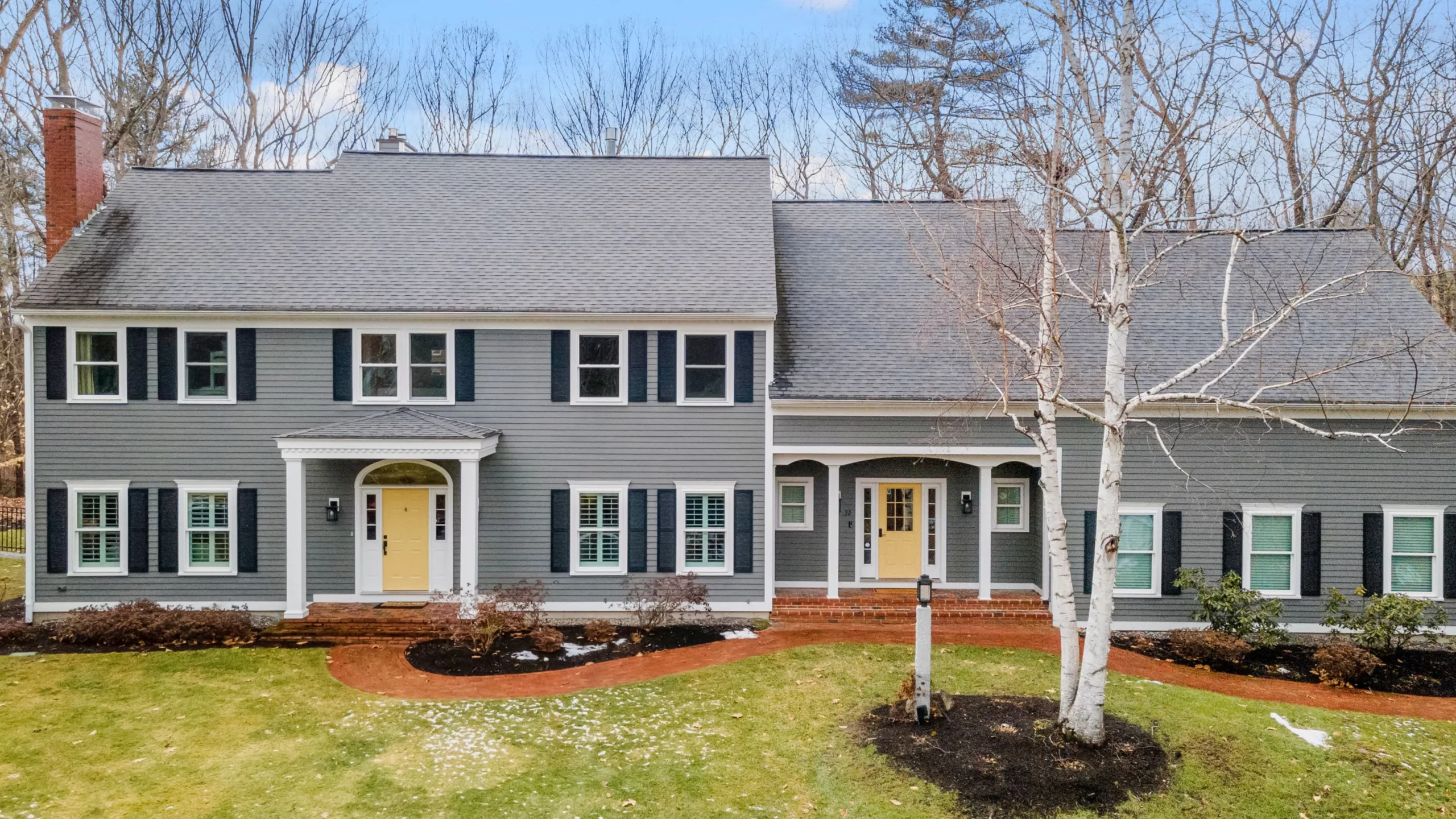 Home with gray siding and gray asphalt shingle roof with well-kept front yard