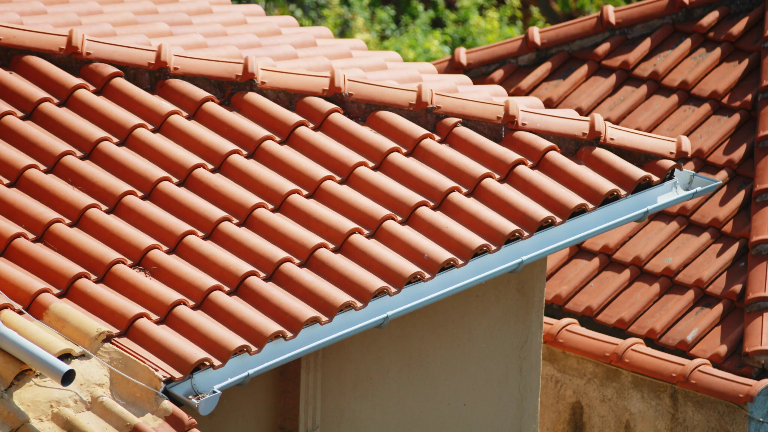 Two homes with bright orange tile roofs on them