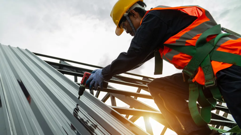 Roofer installing new commercial metal roof