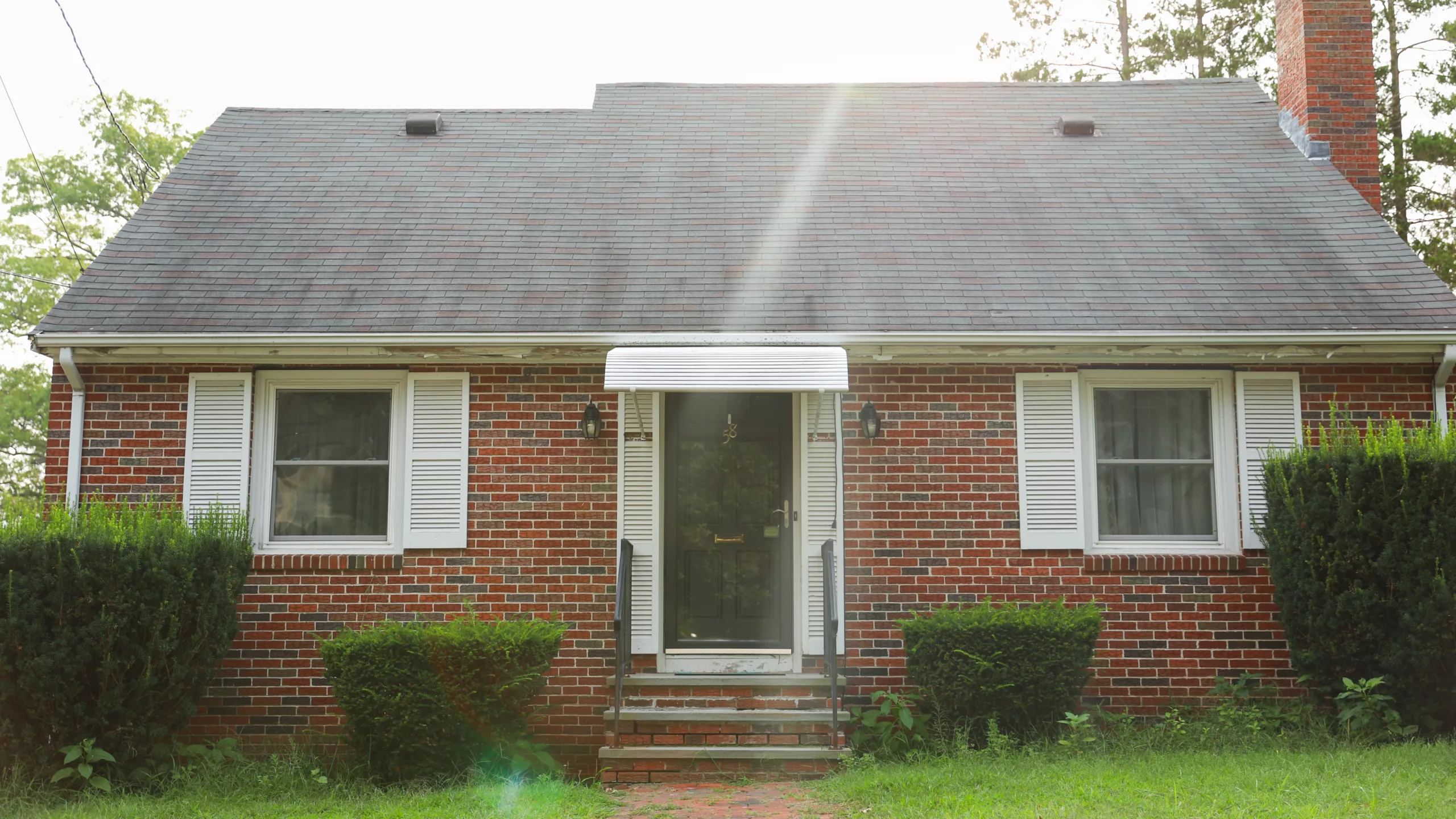 Front view of home with brick siding and new asphalt roofing