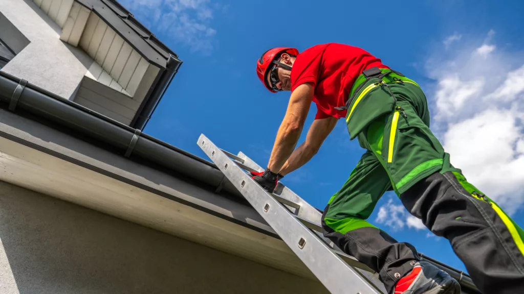 Roofer installing metal gutters on residence in Marble Falls