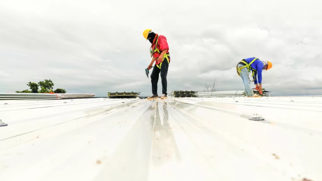 Workers repairing a white flat commercial roof