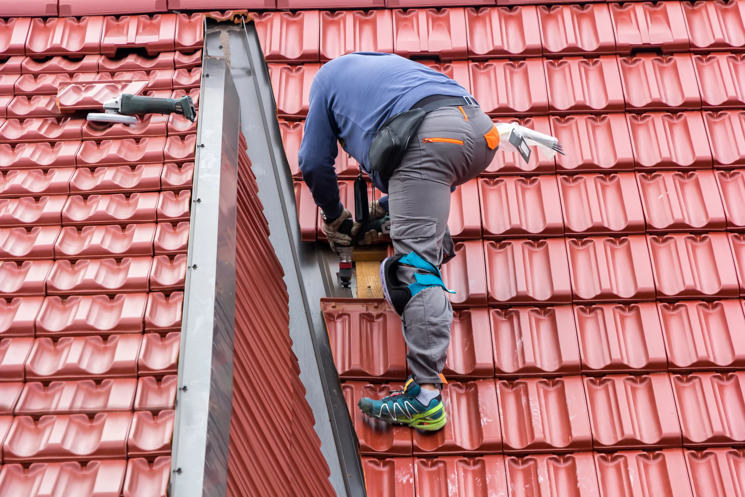 Roofer repairing a red roof