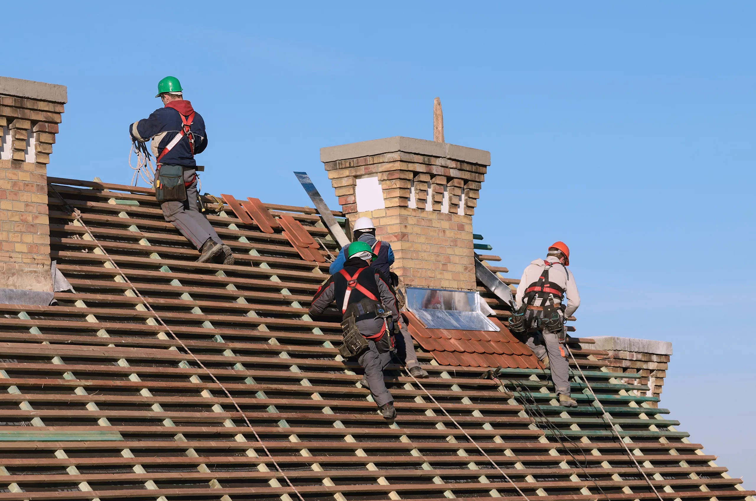 Roofers replacing a roof on a house