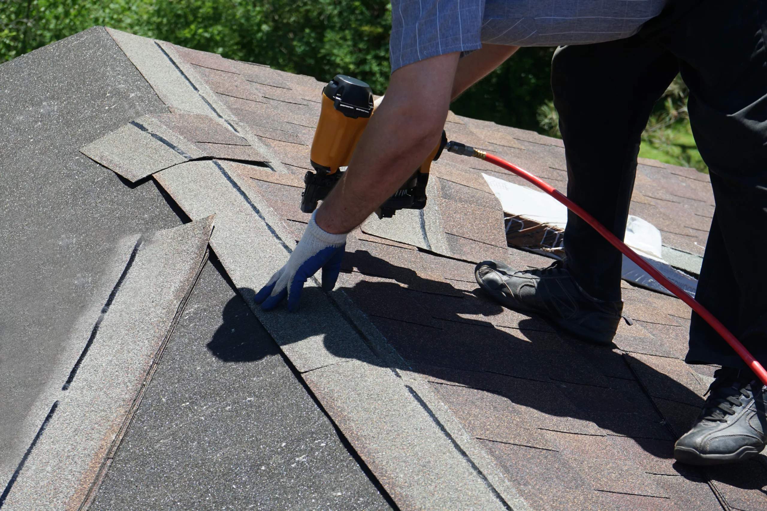 Worker replacing shingles on a roof
