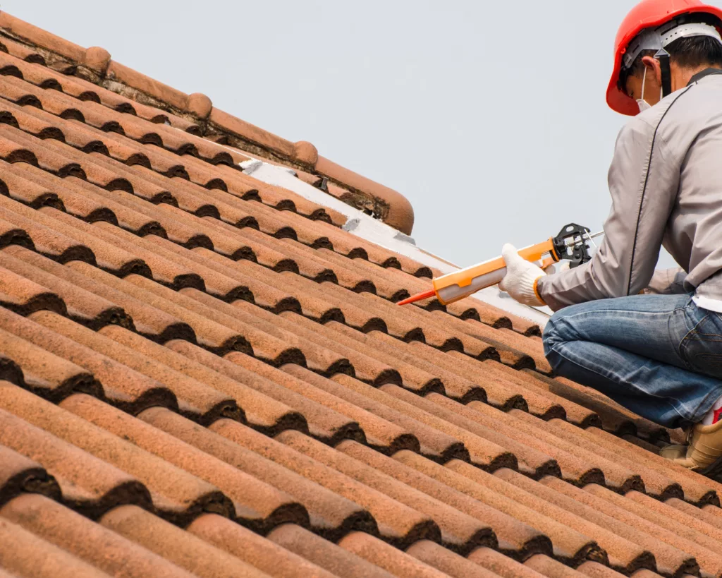 Roofer caulking tile roof
