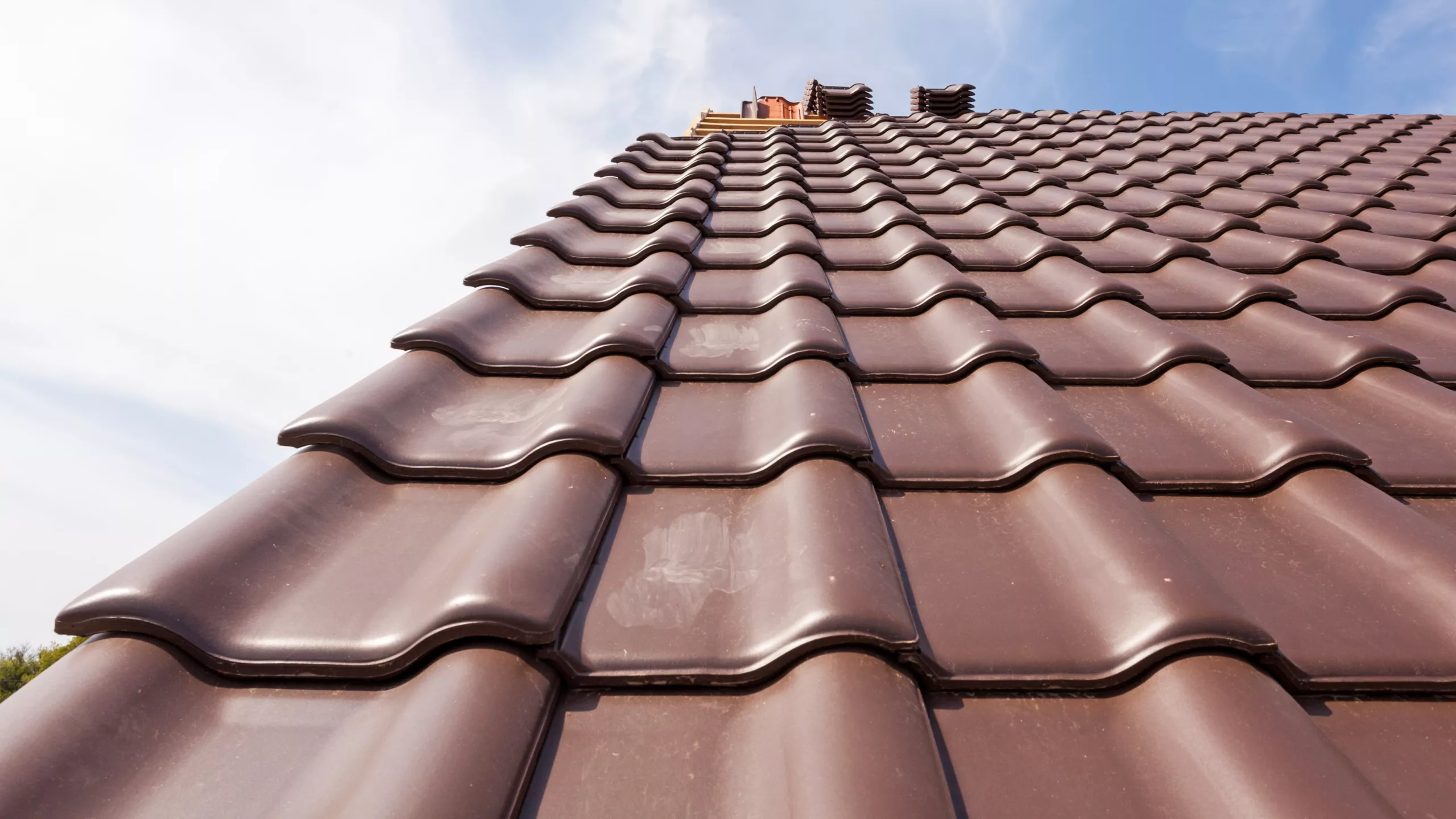 Close-up view of home with new red tile roofing