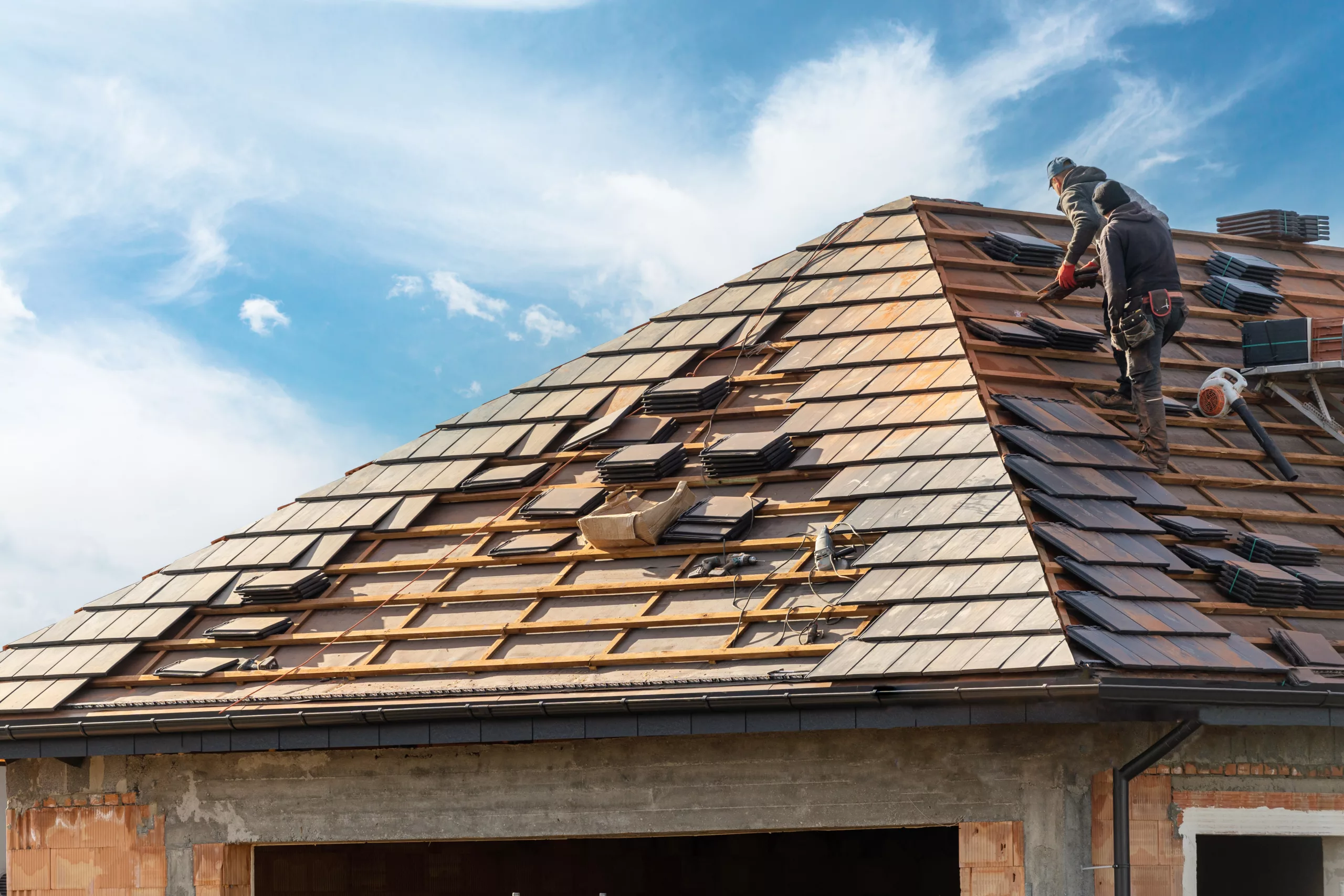 Workers installing a tile roof on a home