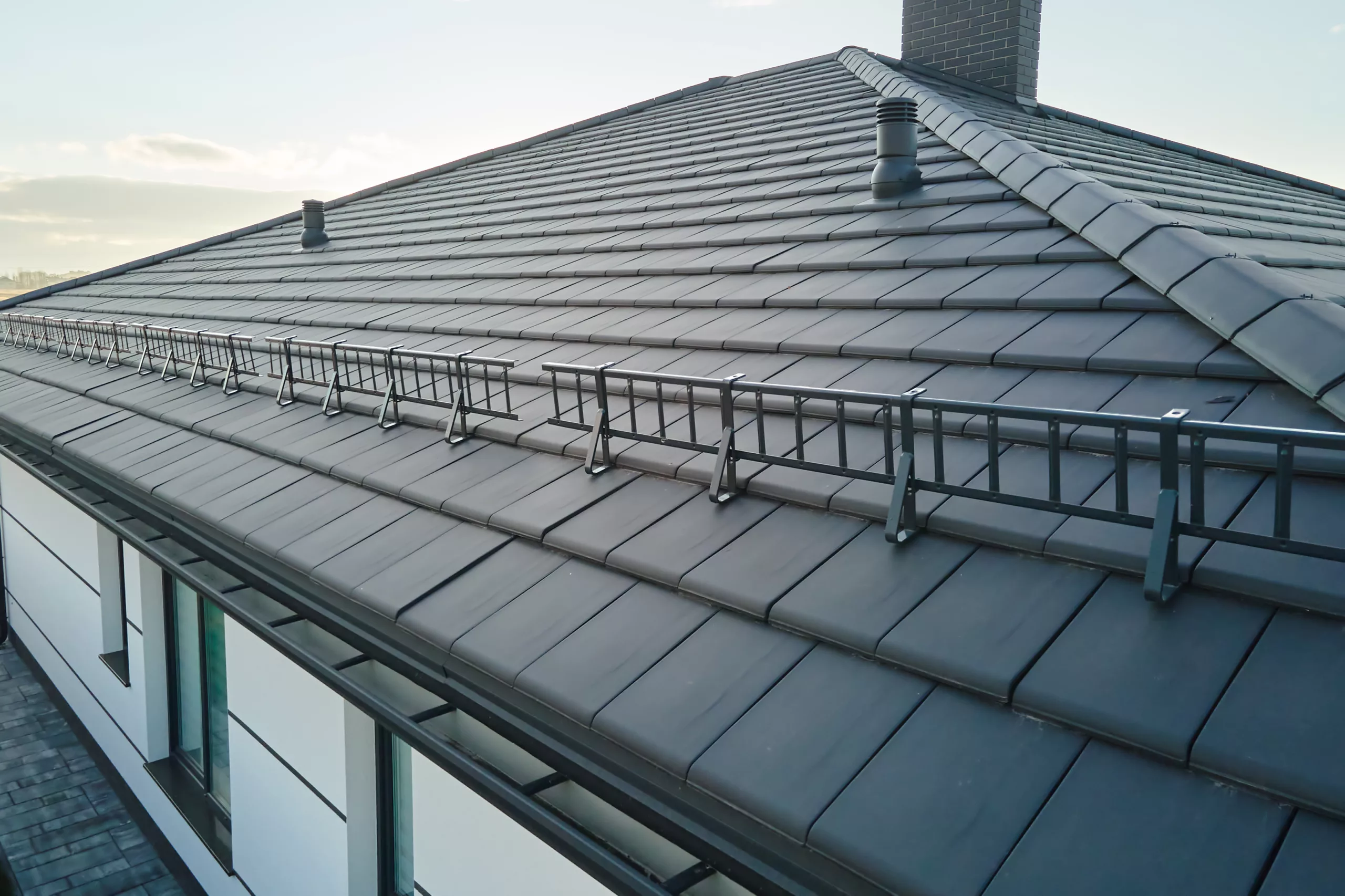 A commercial roof is a stunning black with a chimney and other vents